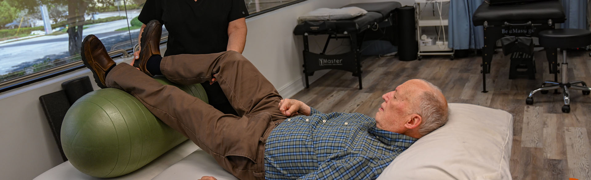 Doctor checking an old man's knee injury and pain relief remedies
