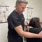 Doctor performing manual adjustment on a patient with a shoulder injury at a rehabilitation clinic