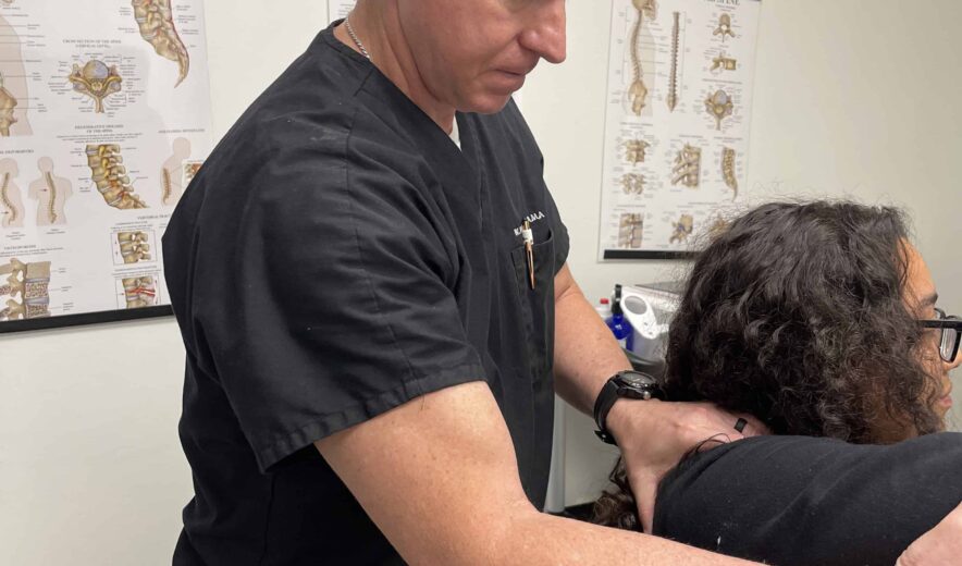 Doctor performing manual adjustment on a patient with a shoulder injury at a rehabilitation clinic