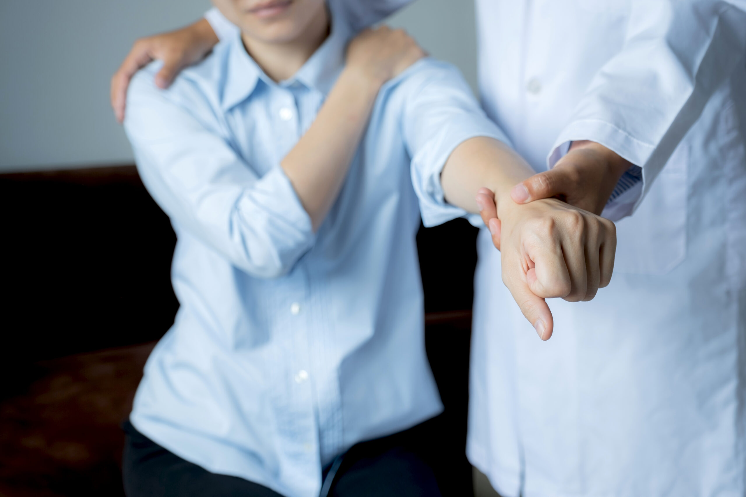 Physical therapist assisting patient with shoulder injury recovery during a rehabilitation session 