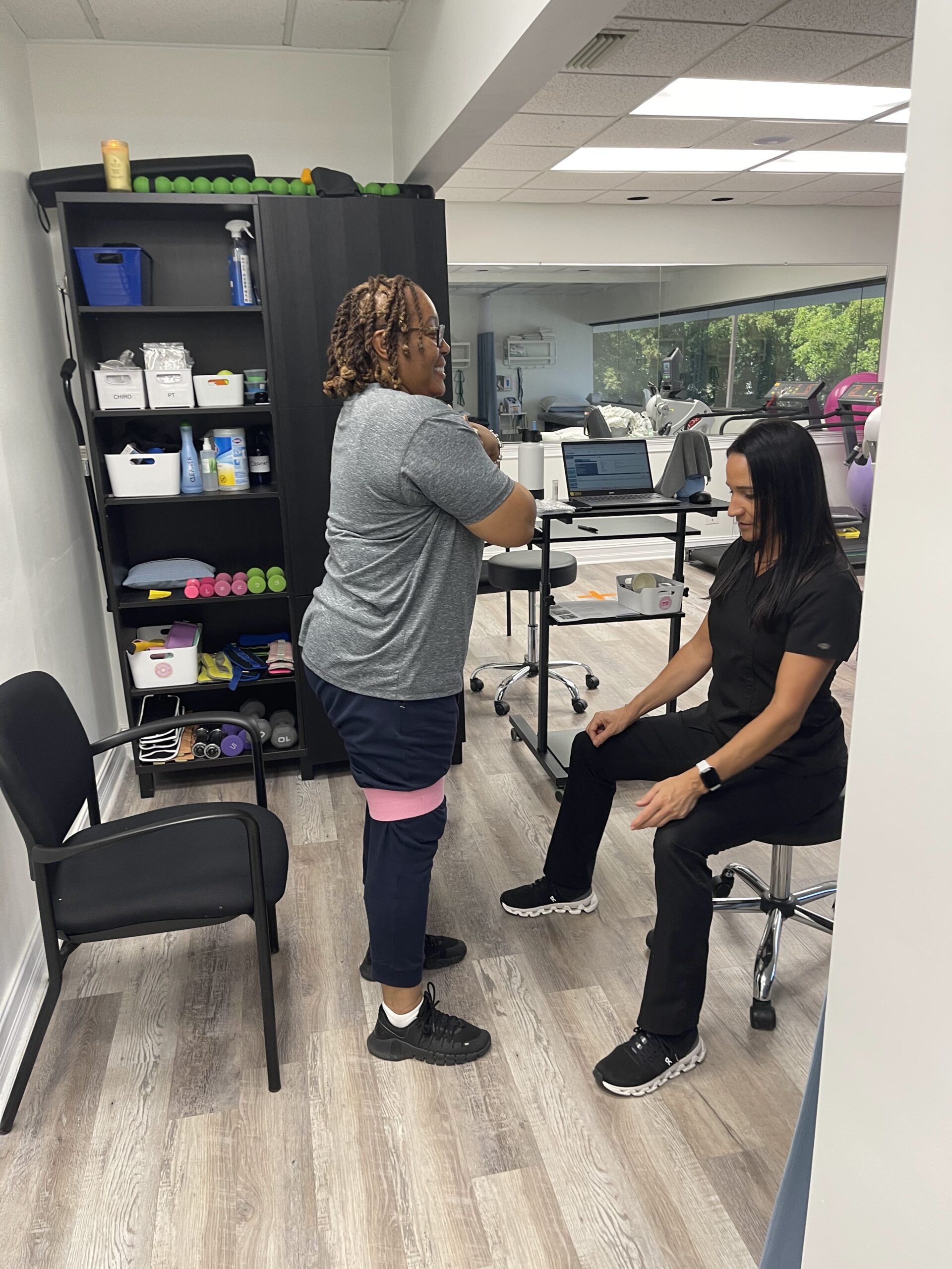 Patient performing resistance band exercise under the supervision of a therapist during physical therapy at a Deerfield Beach clinic