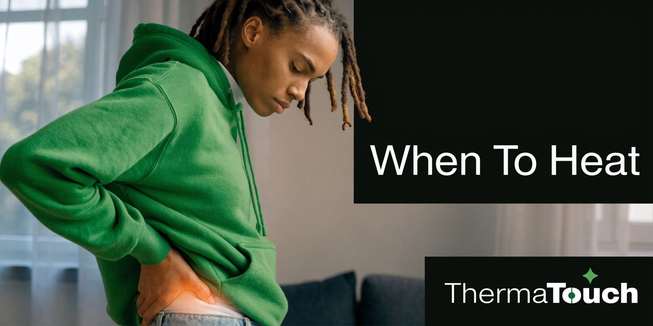 A young person in a green hoodie holding their lower back due to pain and discomfort.