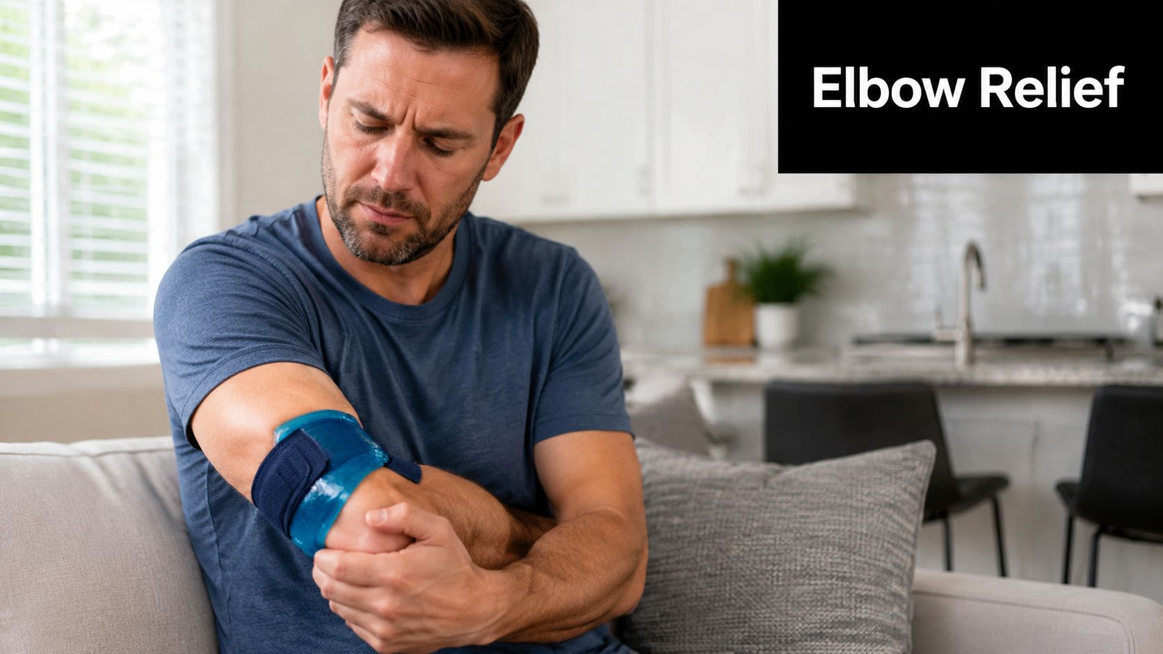 A man sitting on a sofa looking down at his elbow while wearing a blue ice arm sleeve.